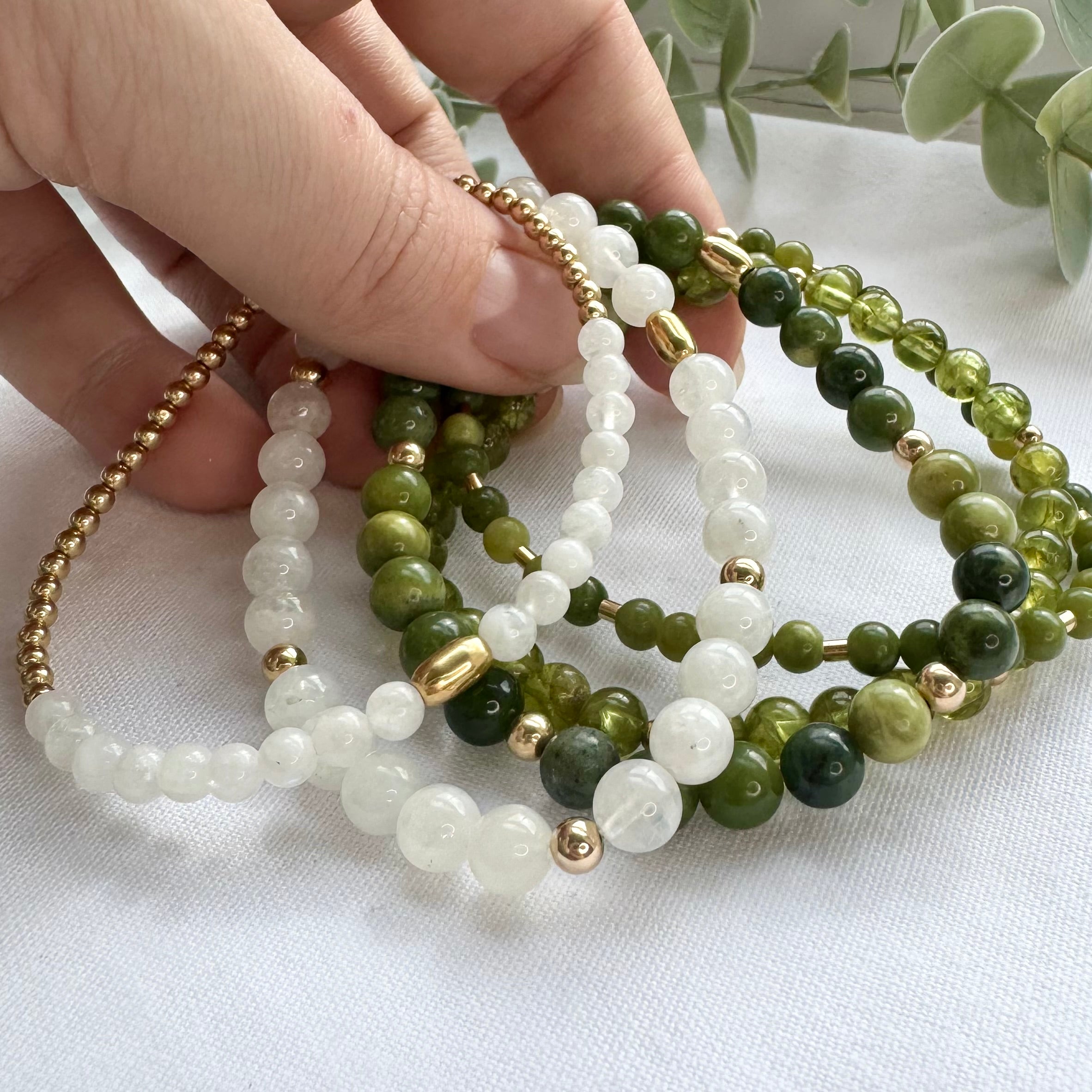 Gemstone and gold stretch bracelets in green and white colouring